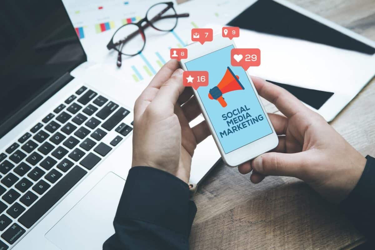 Person holding phone with Social Media Marketing and engagement images. 
