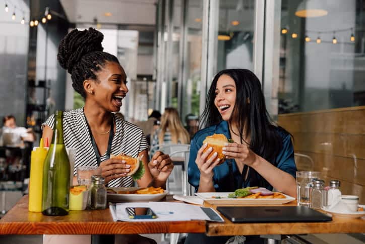Two women eating at a restaurant that uses ctv advertising