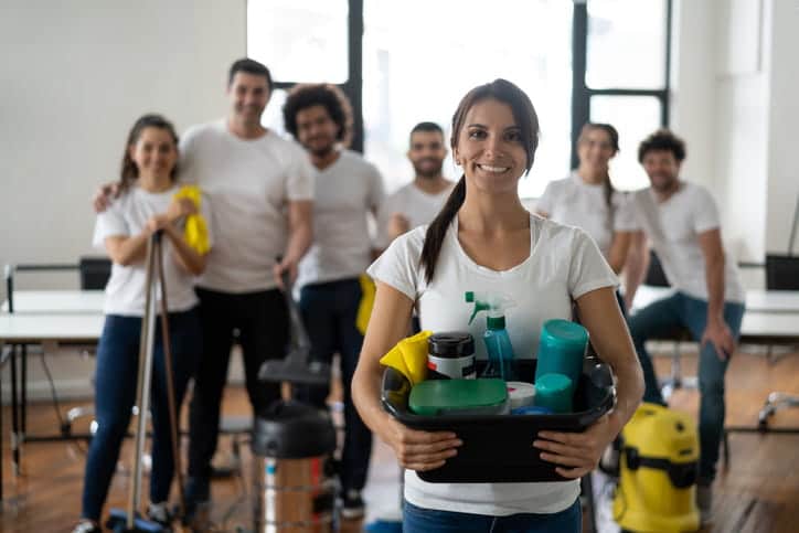 The camera focuses on one cleaner with the rest of her team blurred out in the background.