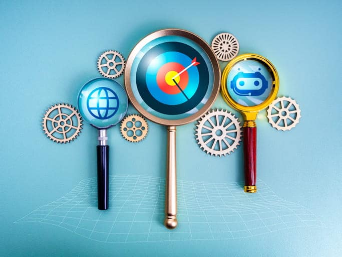 Target dart, internet online globe, and AI bot icons in magnifying glass connected by gears, overtop a blue background.