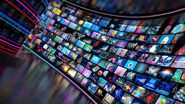 A vibrant digital display featuring numerous colorful screens showcasing various ads and content, arranged in a curved layout with neon lights.