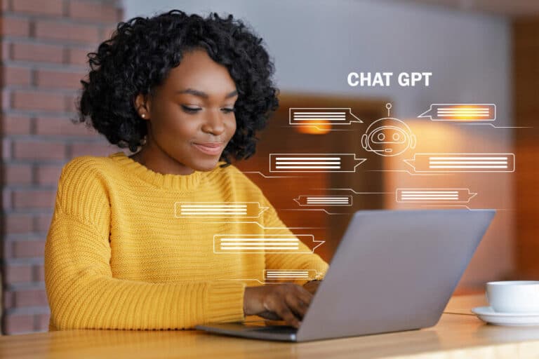 Person using laptop with ChatGPT interface and chat bubbles explaining how to show up in ChatGPT answers using AI SEO strategies